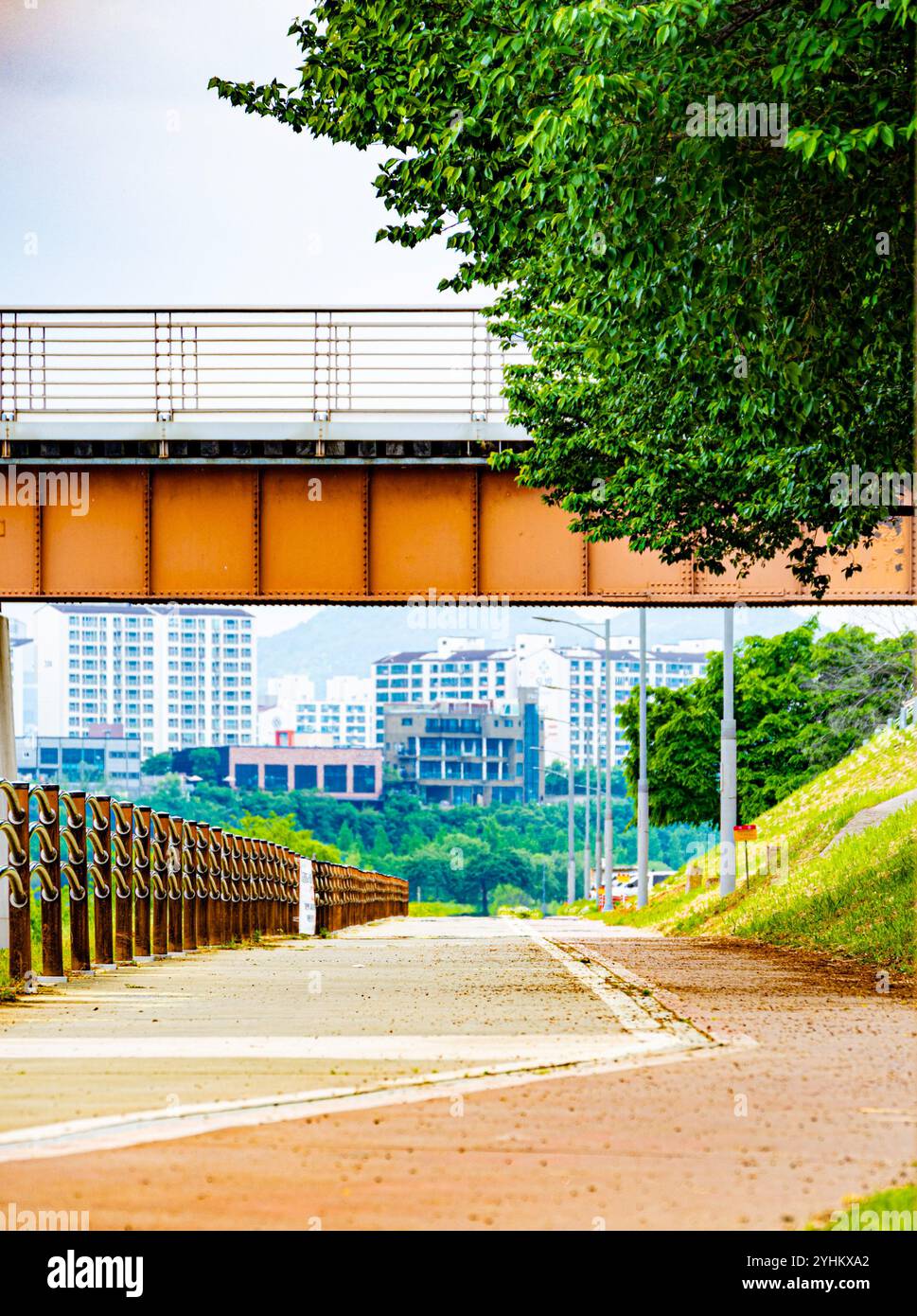 Sentiero sotto il ponte con vista sul paesaggio urbano Foto Stock