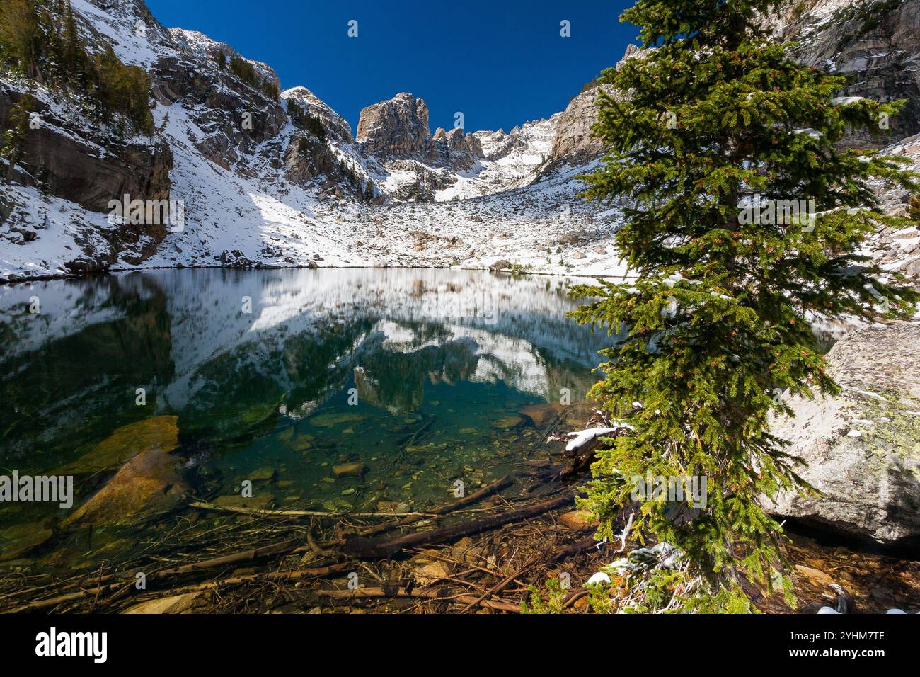 Un fresco strato di neve leggera che si scioglie intorno al perimetro del lago Ramshead nell'Hanging Canyon delle Teton Mountains. Grand Teton National Park, Wyoming Foto Stock