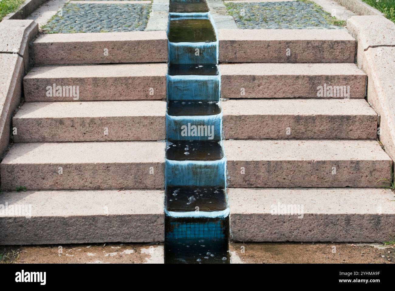 l'acqua scorre tra i gradini di granito in giardino Foto Stock