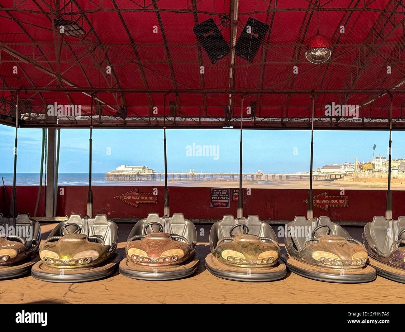 Le auto Dodgem parcheggiate fuori stagione sul molo centrale di Blackpool con spiaggia e North Pier sullo sfondo Foto Stock