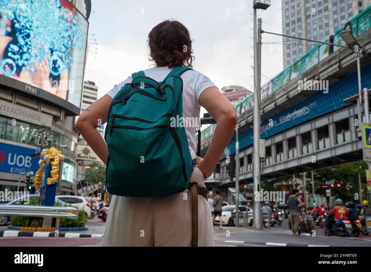 I turisti che esplorano la trafficata strada di bangkok con lo zaino: Abbracciano l'avventura urbana della thailandia Foto Stock