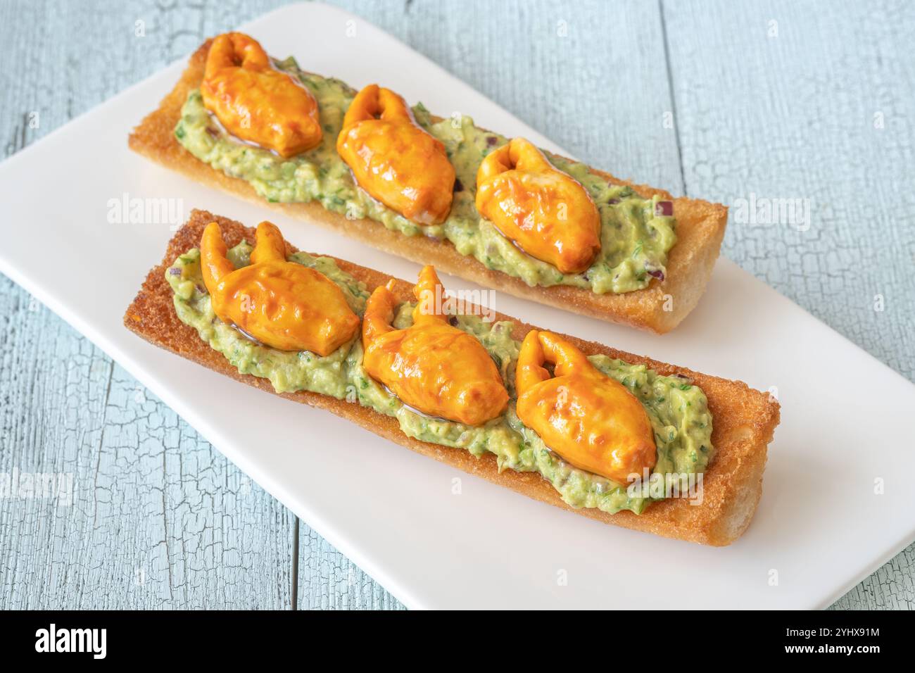 Tosta con guacamole all'avocado e artigli di granchio Foto Stock