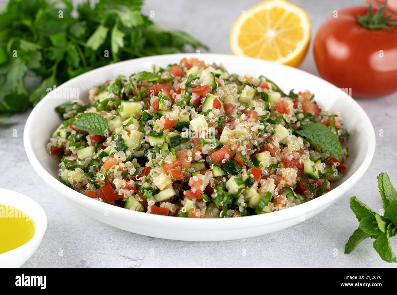 Insalata vegetariana Levantina con quinoa, pomodori, cetrioli, prezzemolo, limone e condimento. Macro. Foto Stock