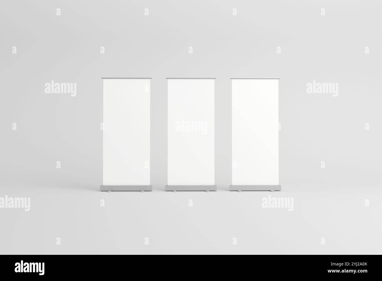 Tre striscioni avvolgibili vuoti con sfondi bianchi, allineati fianco a fianco, ideali per il branding personalizzabile in mostre, fiere o promozioni Foto Stock