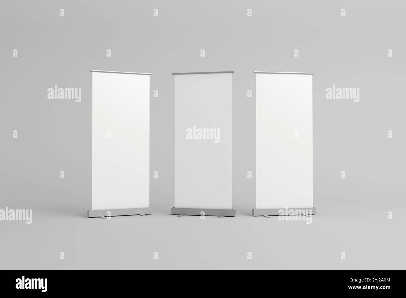 Tre striscioni avvolgibili vuoti con sfondi bianchi, allineati fianco a fianco, ideali per il branding personalizzabile in mostre, fiere o promozioni Foto Stock