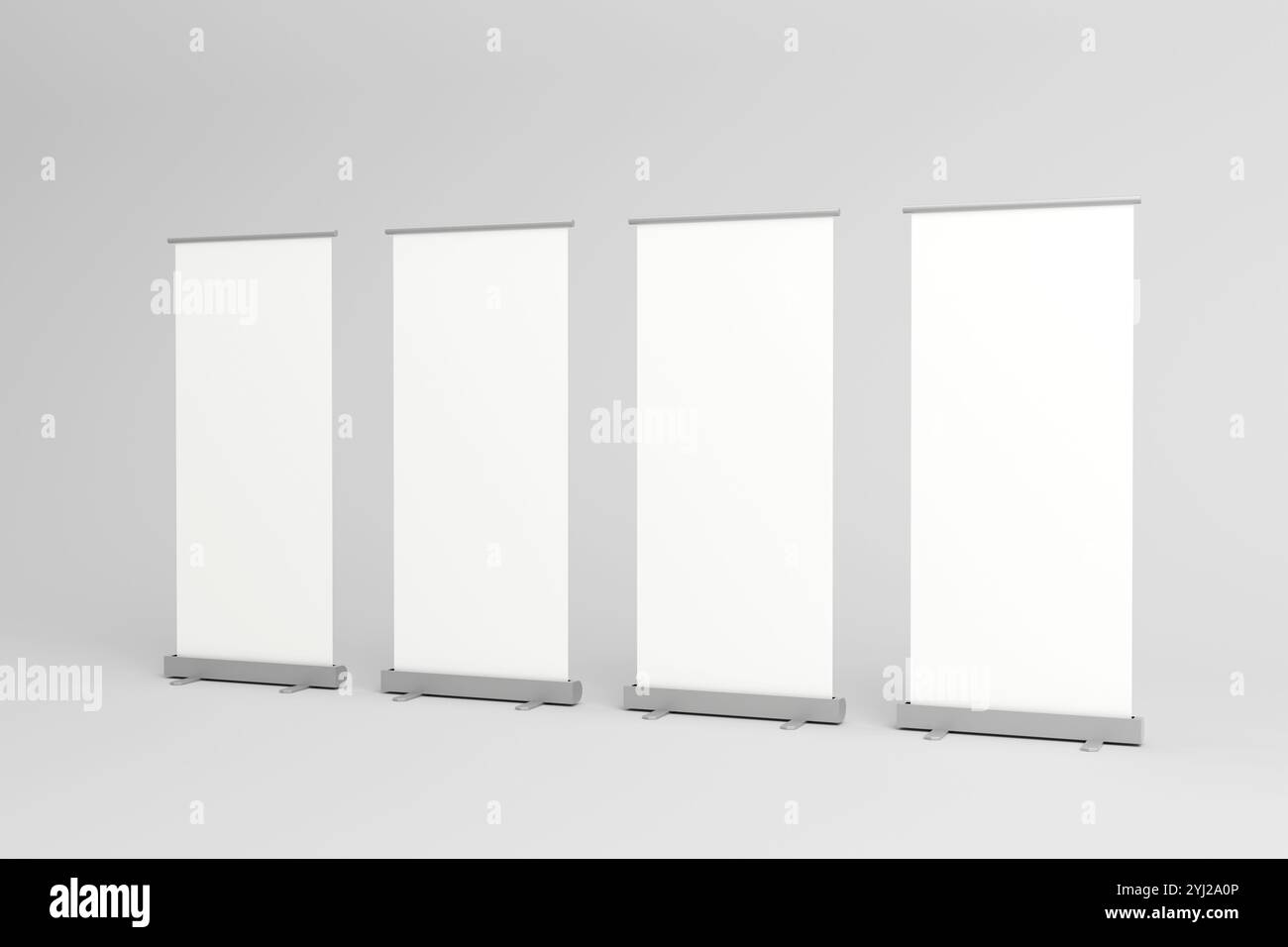 Quattro banner rotanti vuoti con sfondi bianchi, allineati in fila, ideali per il branding personalizzabile in fiere, mostre ed eventi aziendali Foto Stock