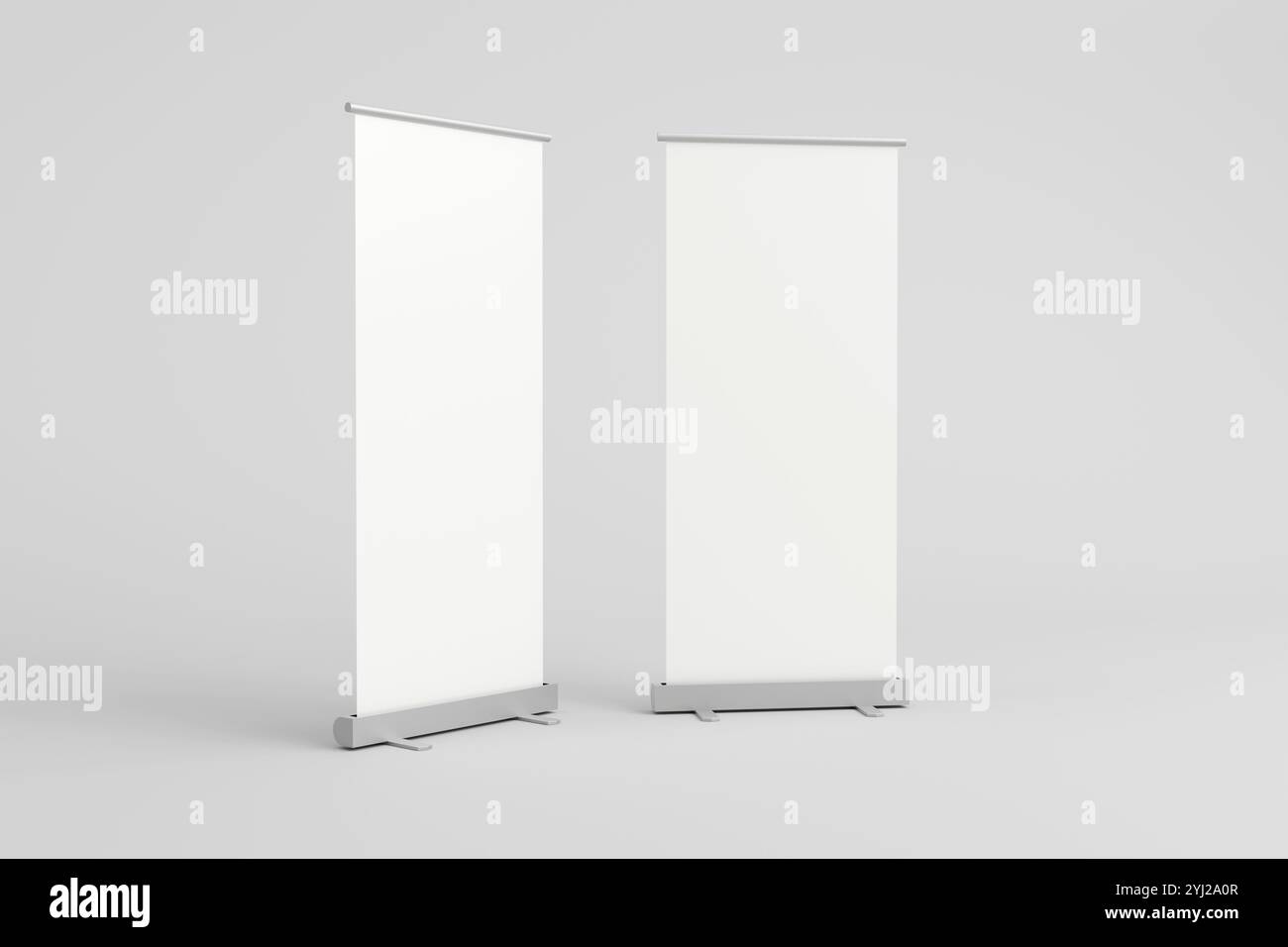 Due banner avvolgibili vuoti con sfondi bianchi su supporti, ideali per il branding personalizzabile in fiere, eventi ed espositori promozionali in un unico formato mini Foto Stock