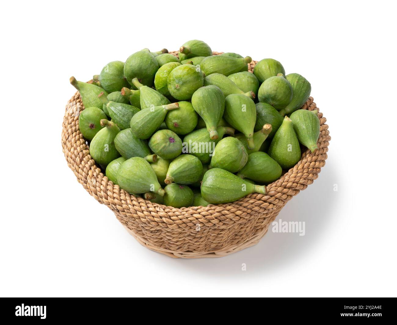 Cestello con fichi verdi non maturi appena raccolti da vicino isolati su sfondo bianco Foto Stock
