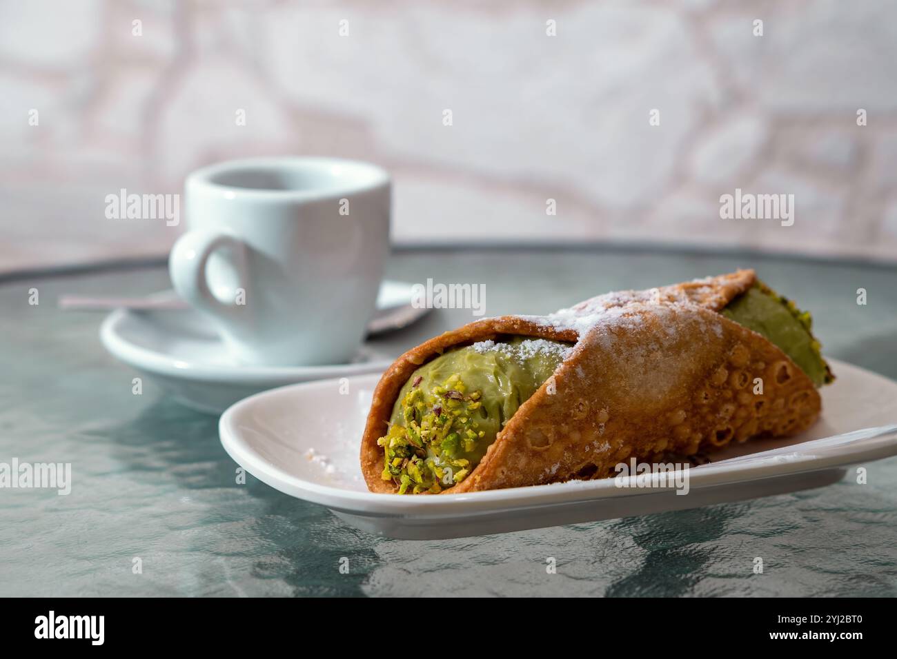 Cannoli al pistacchio siciliano con zucchero a velo serviti su piatto bianco con caffè espresso dessert tradizionale della pasticceria italiana Foto Stock