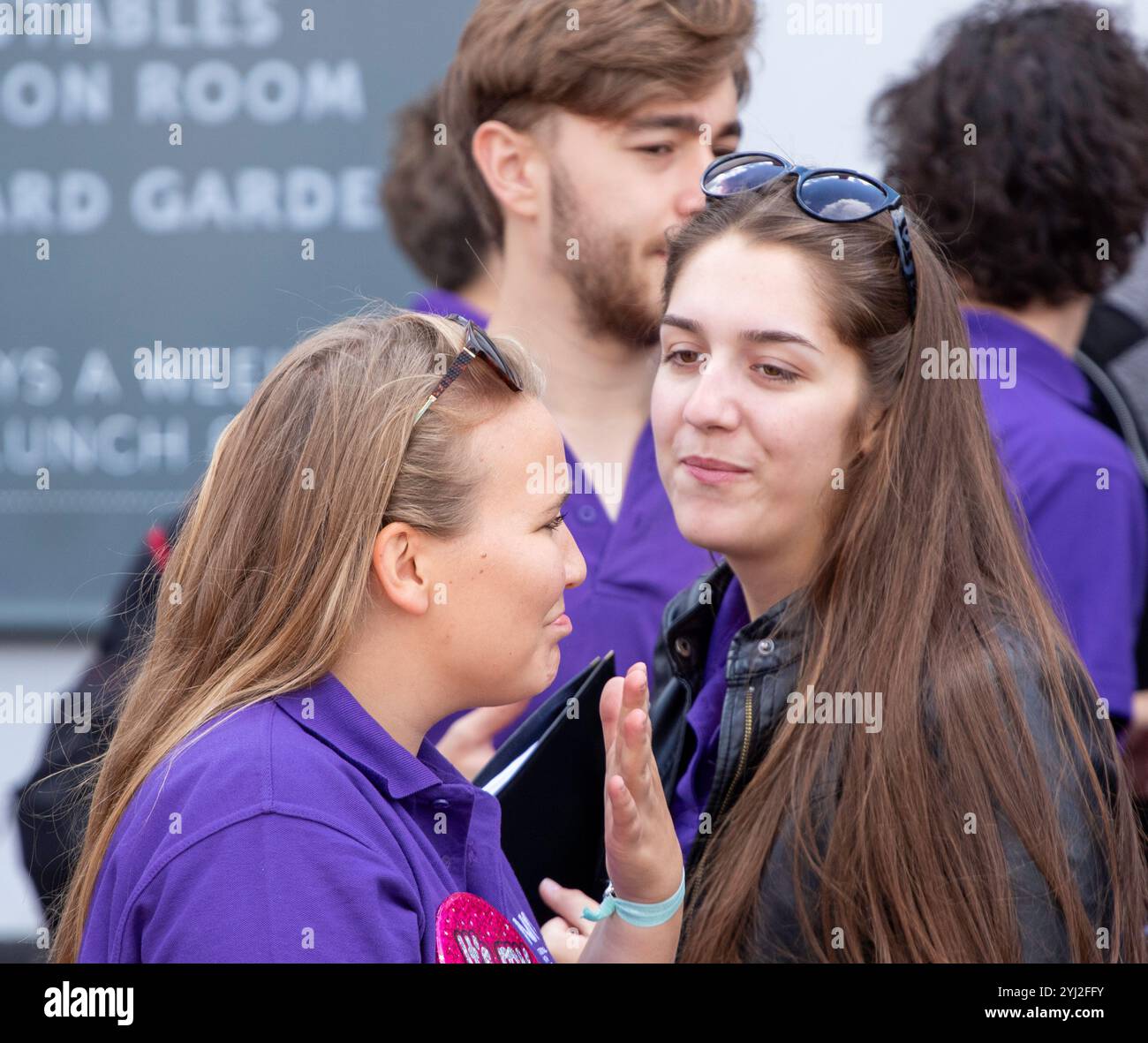 A fine estate a Framlingham Suffolk, il National Youth Choir of Great Britain, con polo viola abbinate, esegue un concerto all'aperto sul mercato Foto Stock