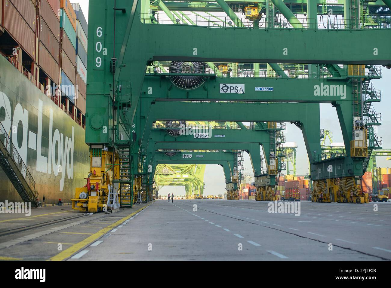 Il cavalletto gru sorvola il marciapiede in un porto commerciale per container durante il giorno, Singapore Foto Stock