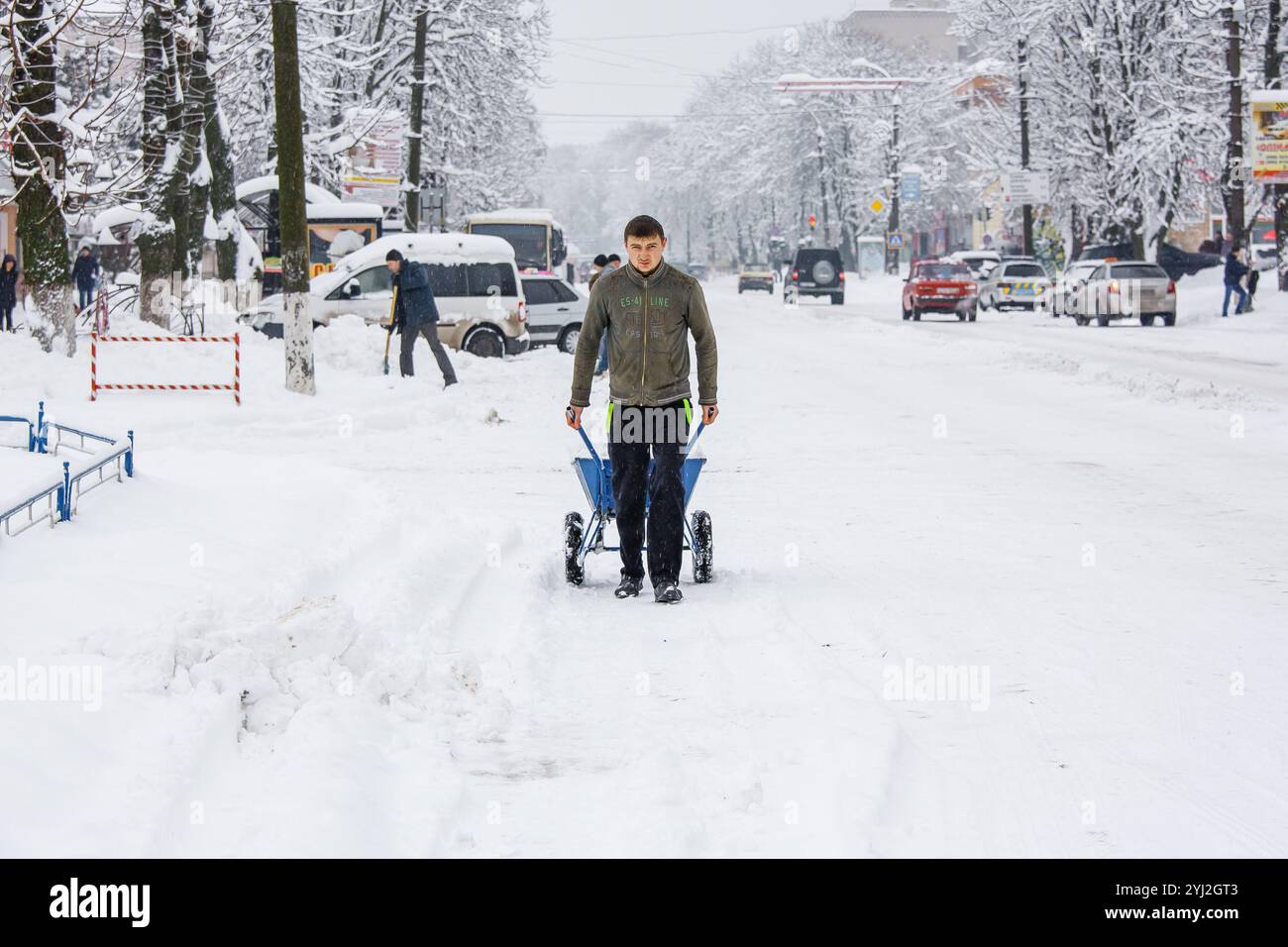Ucraina, la città di Romny, 18 gennaio 2018: Un uomo rimuove la neve dalle strade della città durante una giornata invernale nevosa. Rimozione della neve in città e persone Foto Stock