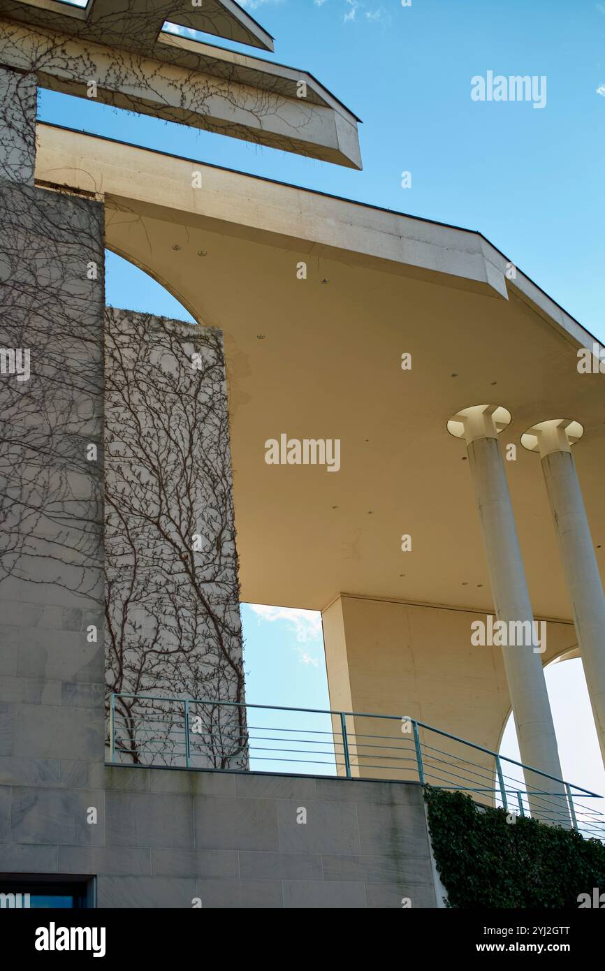 Edificio moderno con architettura geometrica e viti che strisciano su una delle sue pareti di cemento sotto un cielo azzurro, Berlino, Germania Foto Stock