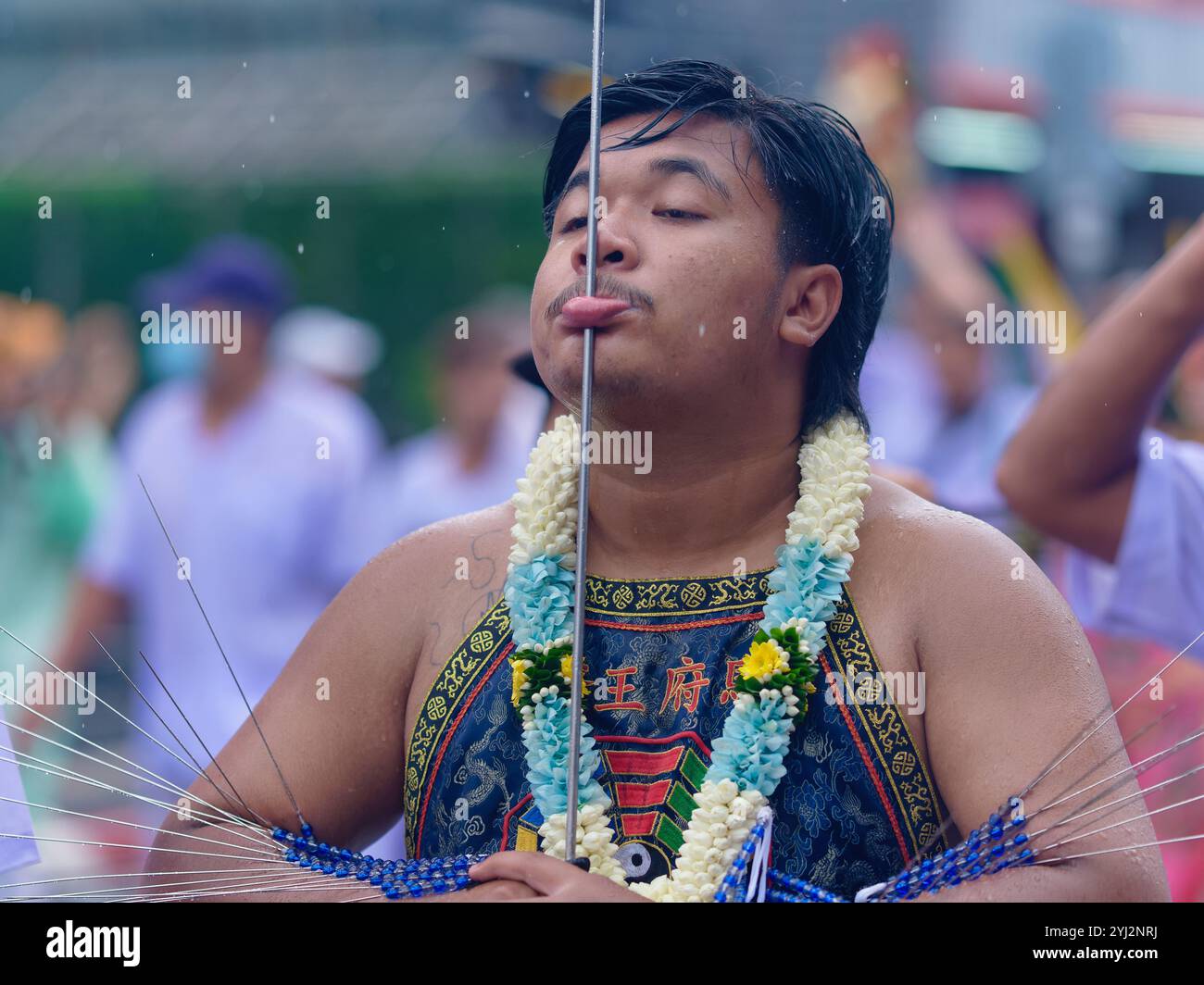 Durante il Vegetarian Festival nella città di Phuket, in Thailandia, un mezzo Mah Song o Spirit mostra un lungo raggio di metallo perforato attraverso la sua lingua Foto Stock