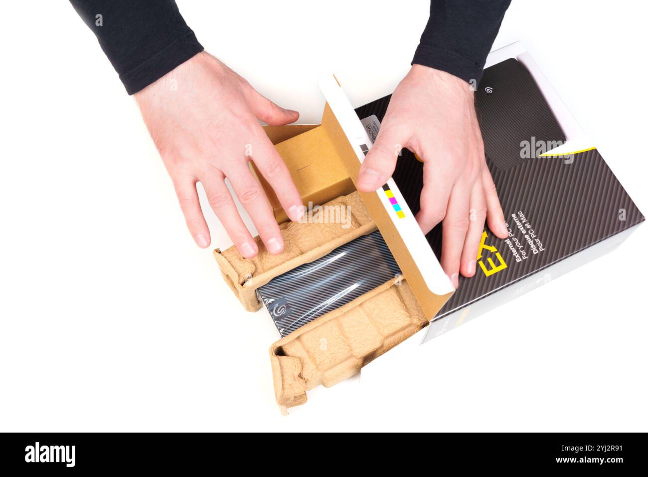 Kiev, Ucraina - 23 ottobre 2024: Mani che rimuovono attentamente il disco rigido esterno Seagate Expansion dalla confezione protettiva, mostrando il design del prodotto Foto Stock