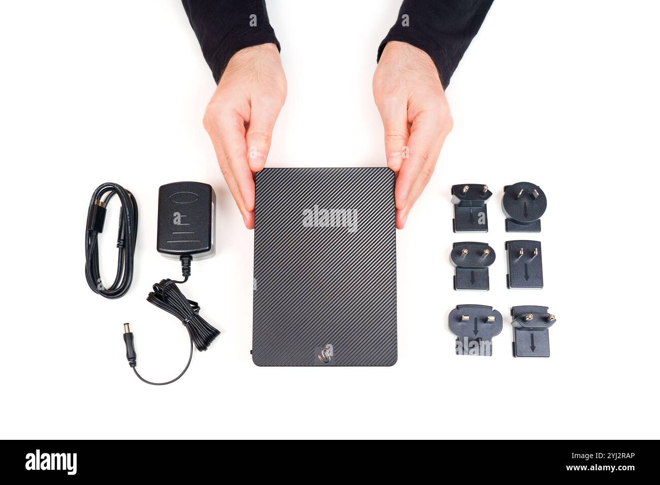 Kiev, Ucraina - 23 ottobre 2024: Persona che dimostra il disco rigido portatile Seagate Expansion con adattatore di alimentazione, cavi e vari tipi di spina su un W Foto Stock