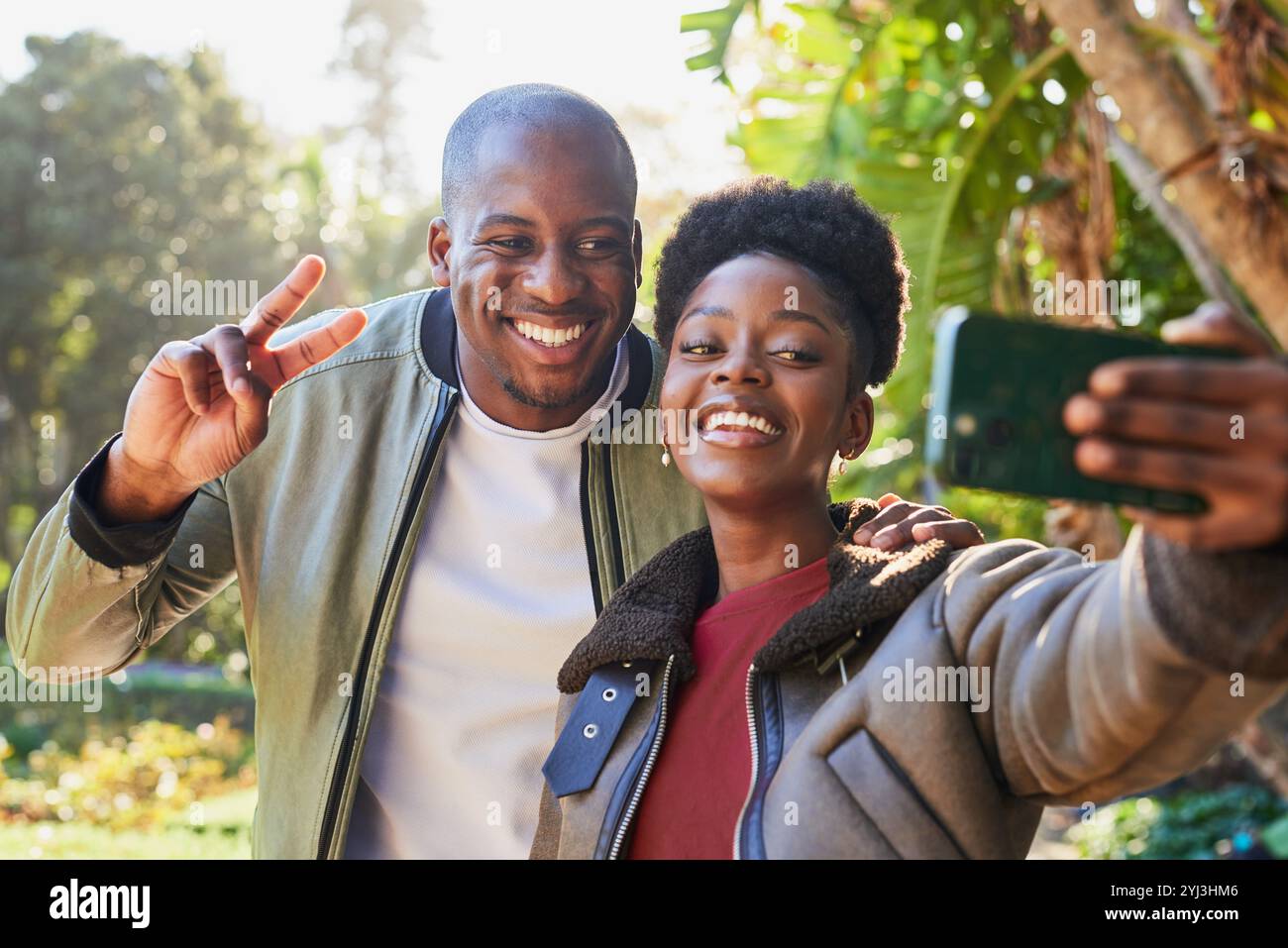 Una coppia allegra che si prende un selfie all'aperto in un bellissimo ambiente di Green Park in un luminoso giorno di sole Foto Stock