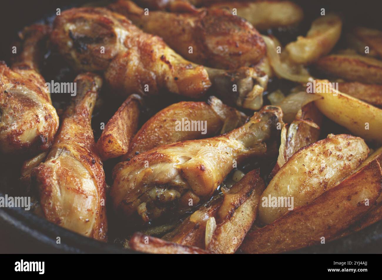 Cosce di pollo fritte con fette di patate, in una teglia di argilla, cotte nel forno, con spezie, fatte in casa, nessuno Foto Stock