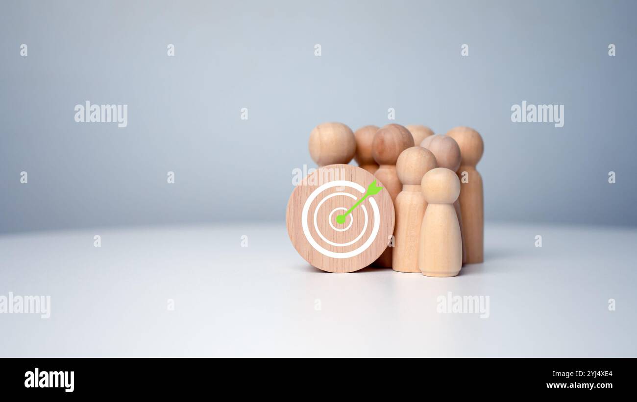 Bambole di legno in piedi intorno al bordo di freccette per la creazione e il targeting degli obiettivi aziendali. Obiettivo del concetto di azienda e del personale in un'azienda. Marketi Foto Stock