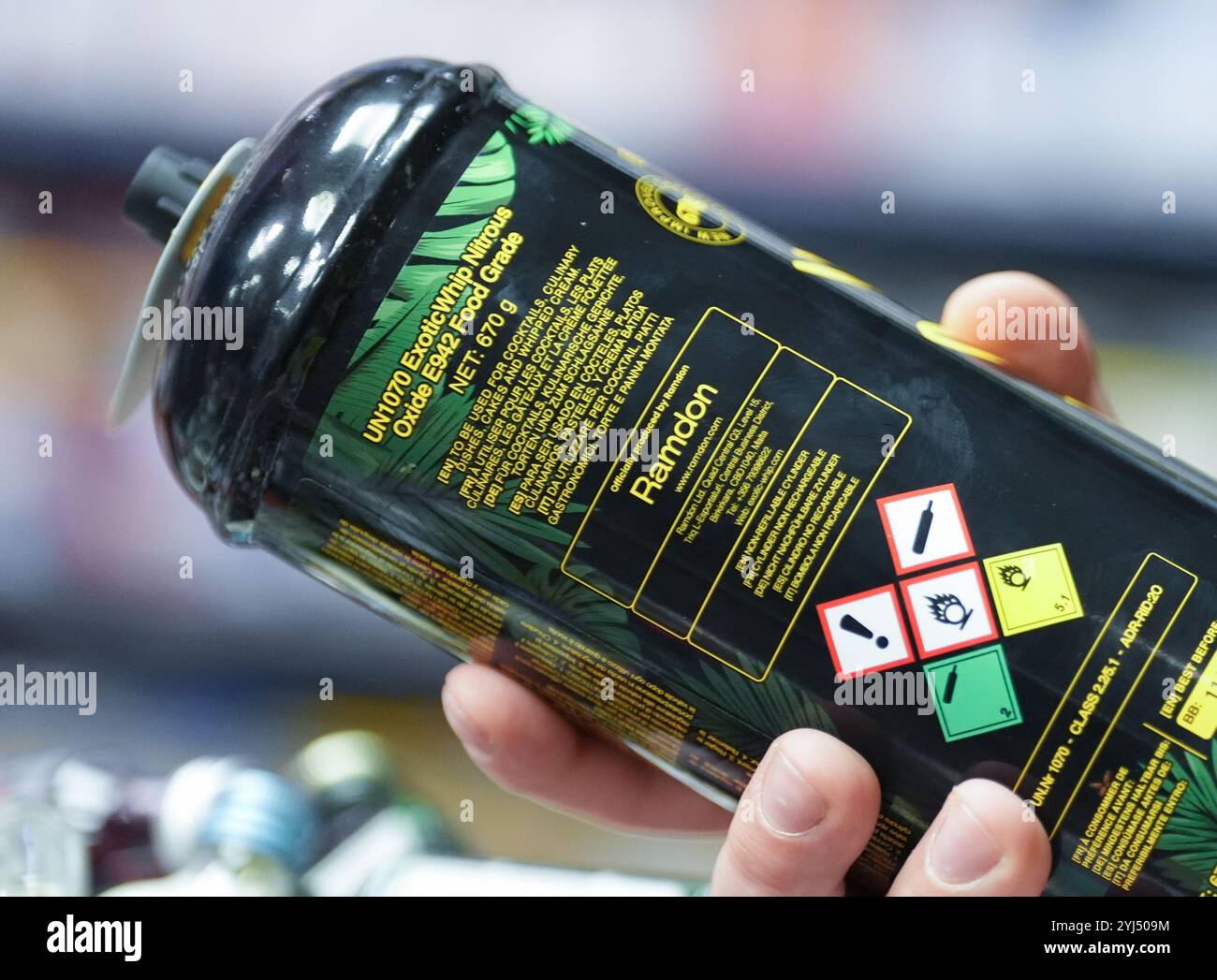 Amburgo, Germania. 13 novembre 2024. ILLUSTRAZIONE - un dipendente ha in mano una lattina di gas ridendo al bancone di un chiosco. L'uso di gas ridendo come droga da festa, soprattutto tra i giovani, potrebbe presto essere vietato in Germania. Il governo federale ha approvato un progetto del ministro della salute Lauterbach (SPD), che prevede anche un divieto di distribuzione tramite distributori automatici e negozi notturni. Crediti: Marcus Brandt/dpa/Alamy Live News Foto Stock