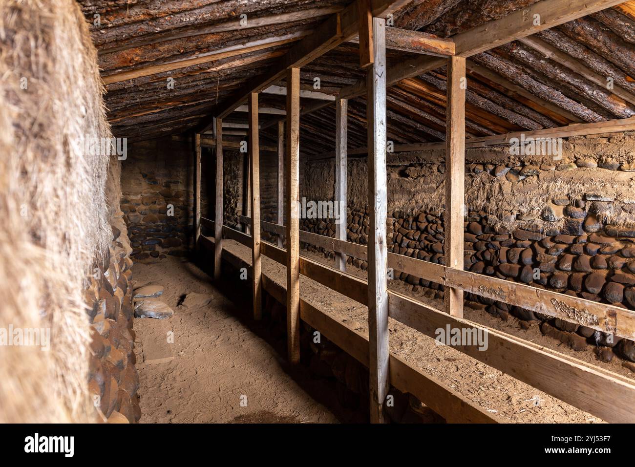 Le case in erba della fattoria Hjardarhagi (Torfhusin i Hjardarhaga), vista interna della tradizionale tovaglia con linea di alimentazione delle pecore, Islanda. Foto Stock