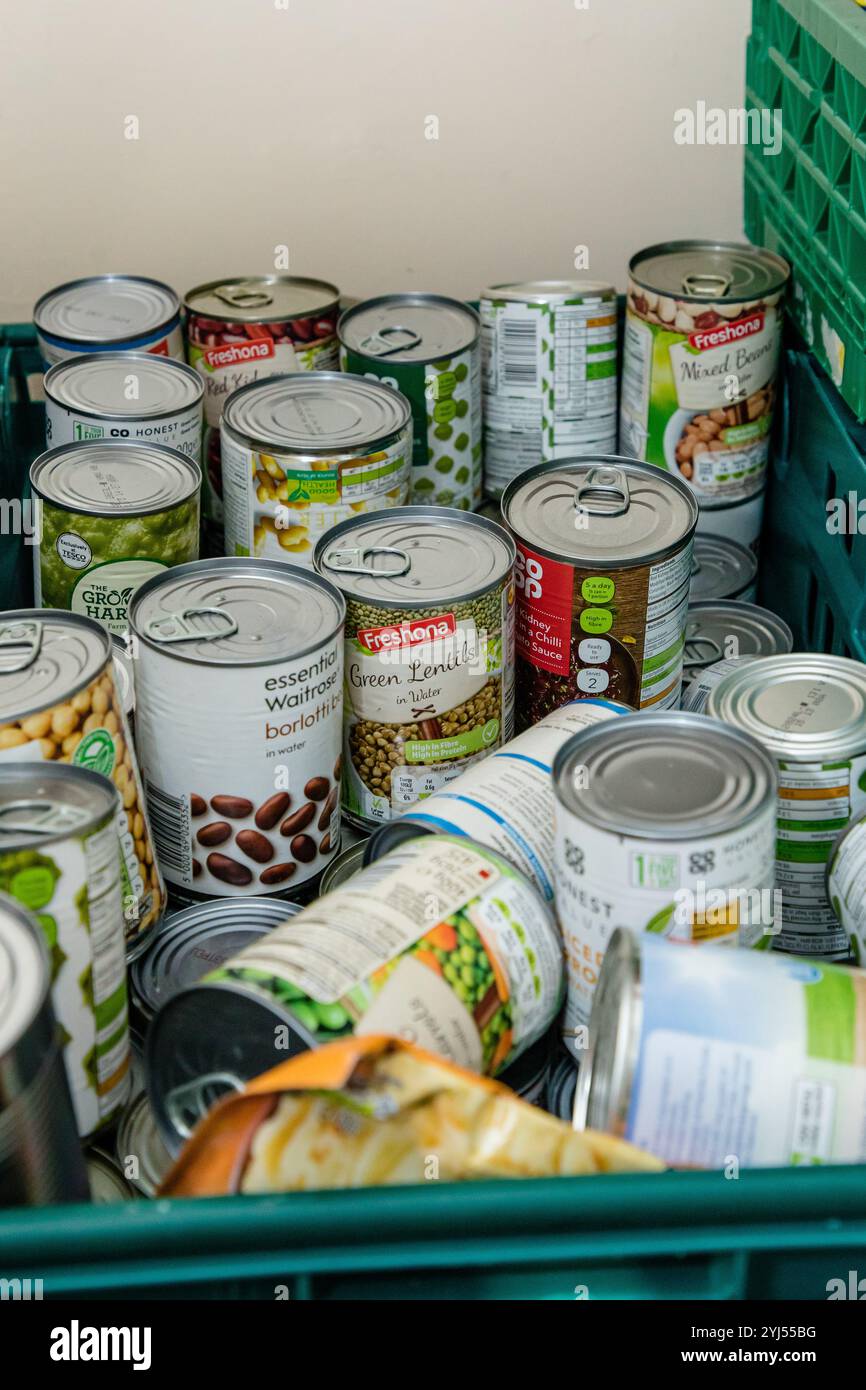 Cibo e lattine in una banca alimentare pronta per essere distribuita alle famiglie che lottano per far fronte alla crisi finanziaria attuale Foto Stock