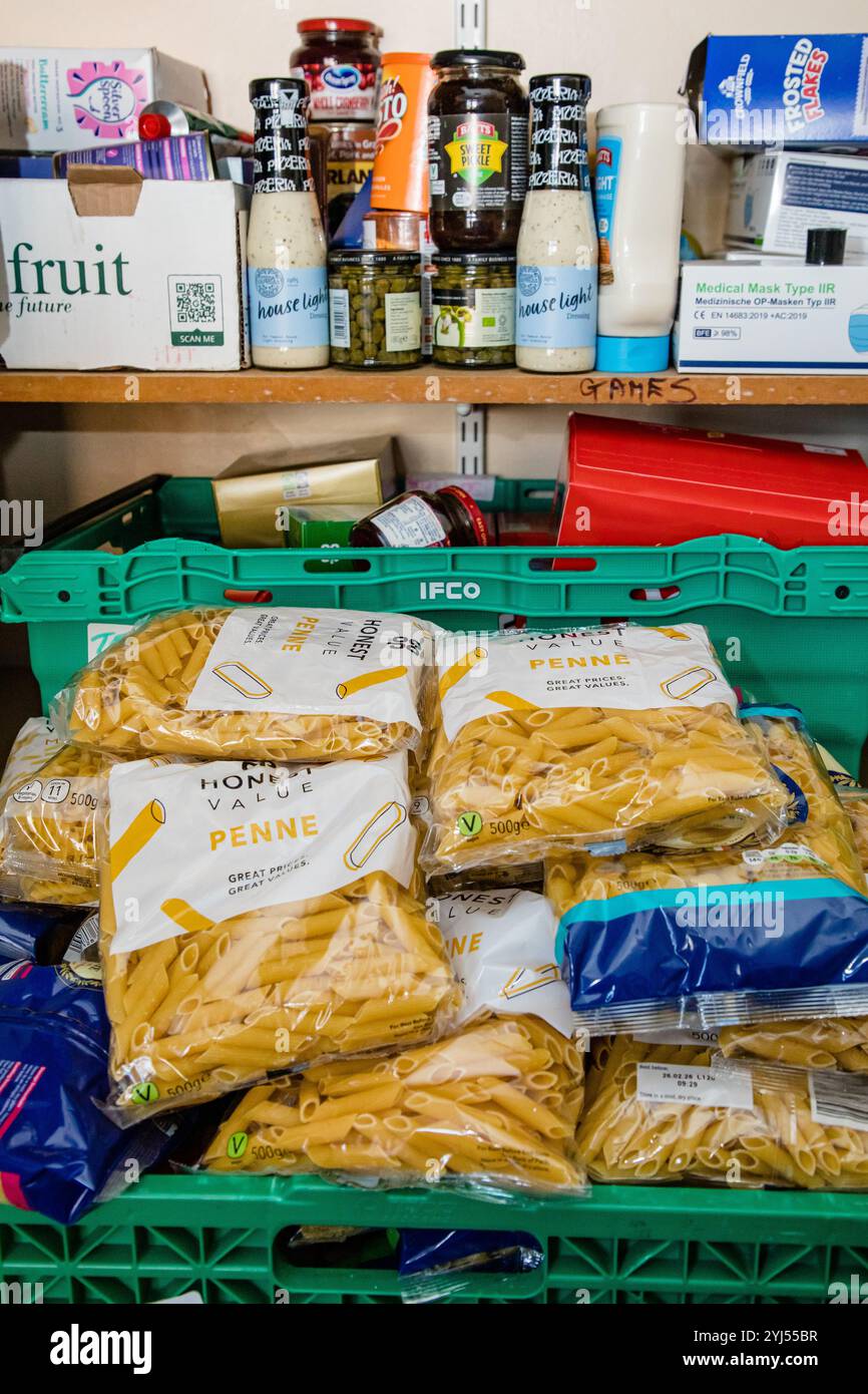 Cibo e lattine in una banca alimentare pronta per essere distribuita alle famiglie che lottano per far fronte alla crisi finanziaria attuale Foto Stock