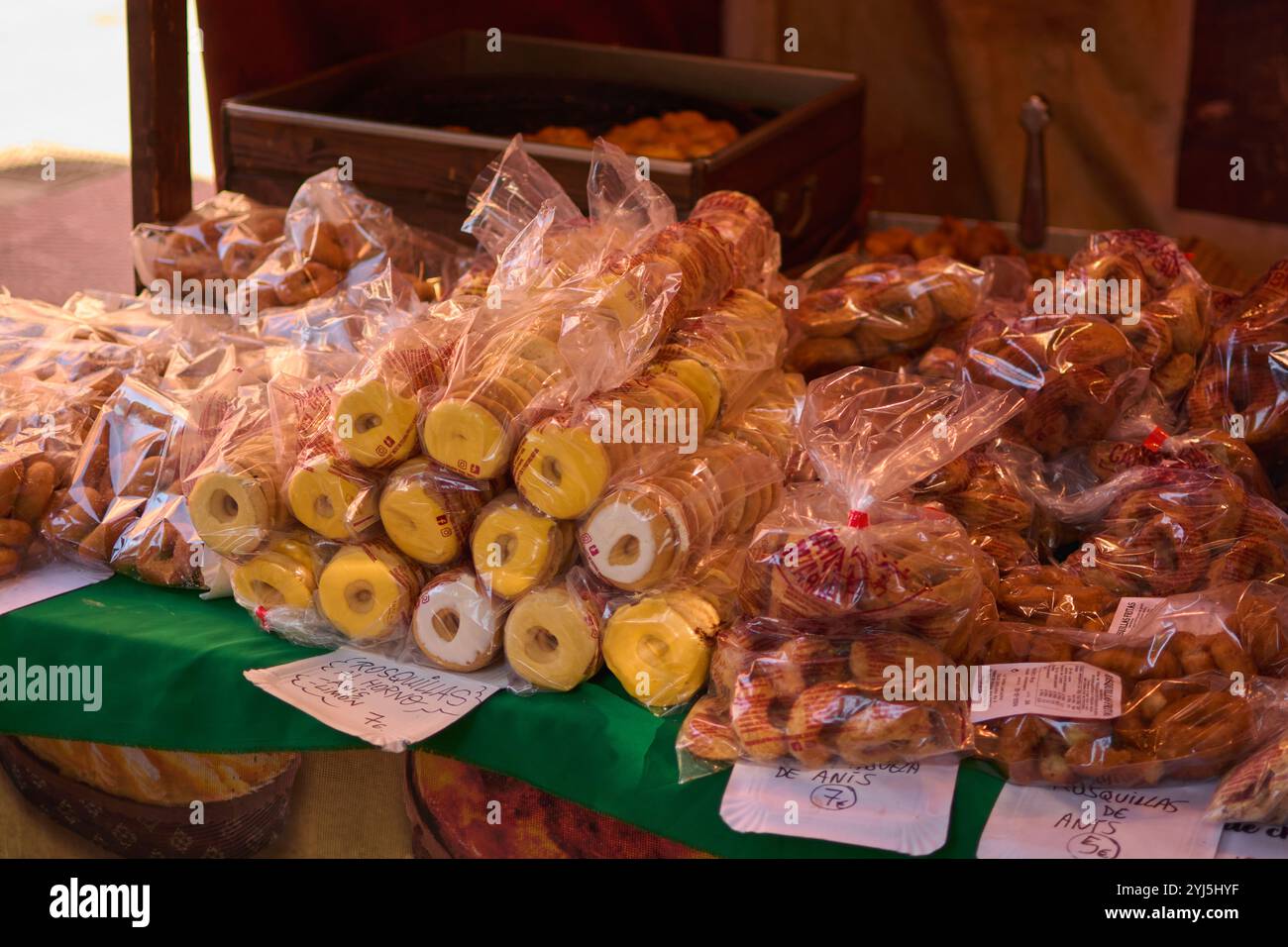 Un bancone del mercato che espone una varietà di ciambelle appena sfornate in una confezione in plastica trasparente, con diversi tipi e sapori, perfetto per un dolce tr Foto Stock