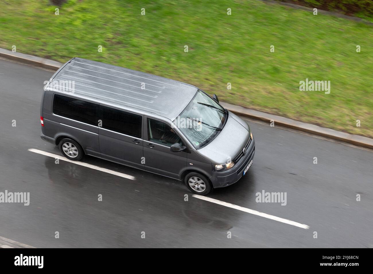 OSTRAVA, CECHIA - 23 MARZO 2024: Volkswagen Transporter T5 TDI Caravelle con effetto di sfocatura del movimento su strada bagnata Foto Stock