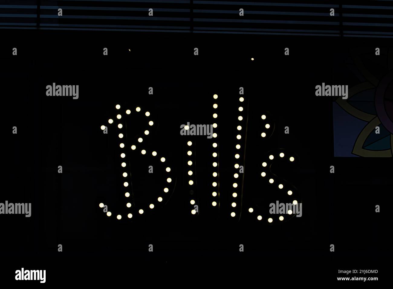Immagine ravvicinata di un cartello "Bills" illuminato da lampadine bianche su sfondo scuro. Foto Stock