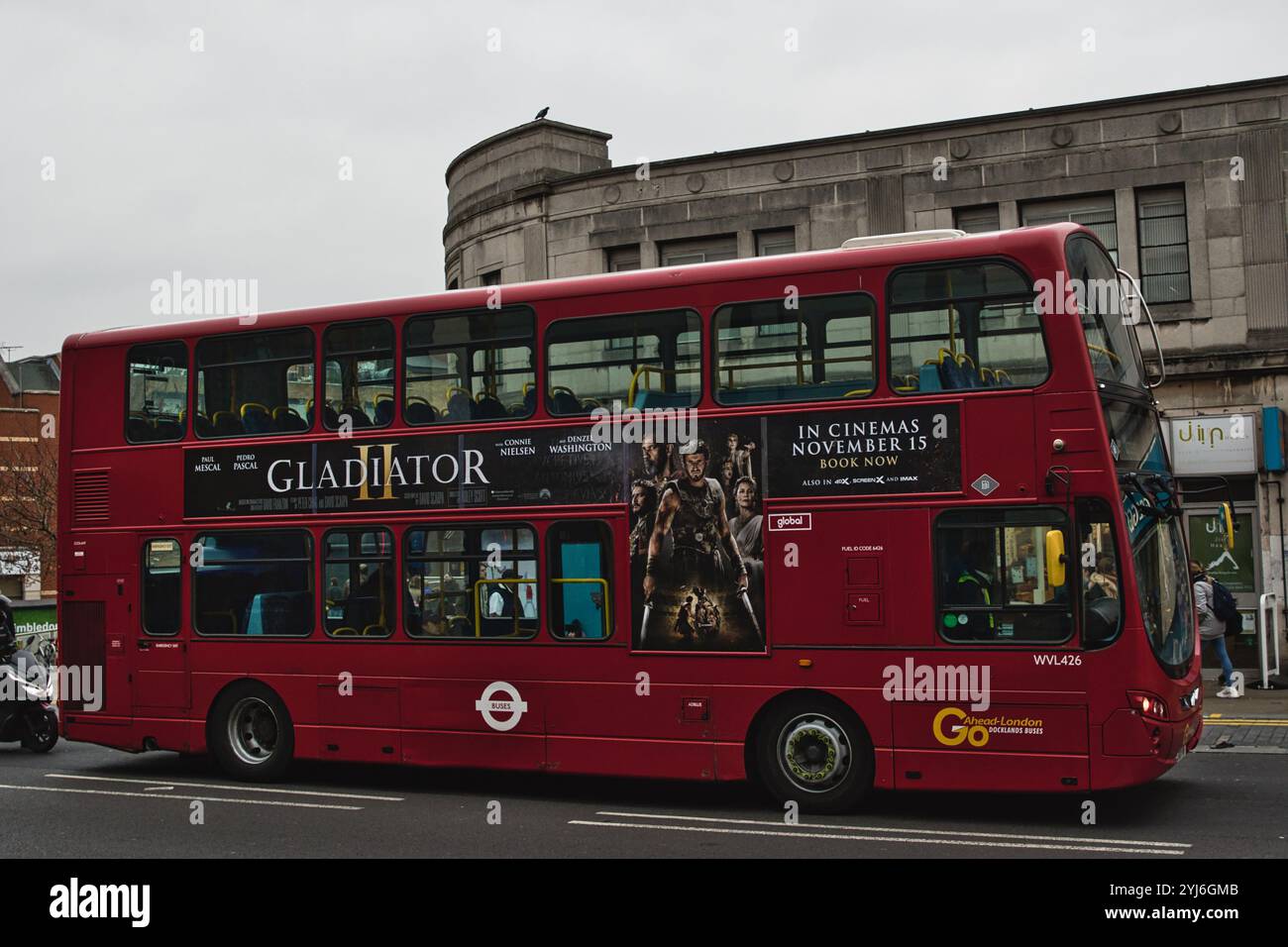 Un autobus rosso a due piani con un poster del film "Gladiator II" sul lato. L'autobus è parcheggiato sulla strada e si affaccia sulla destra. L'autobus ha un Londo Foto Stock