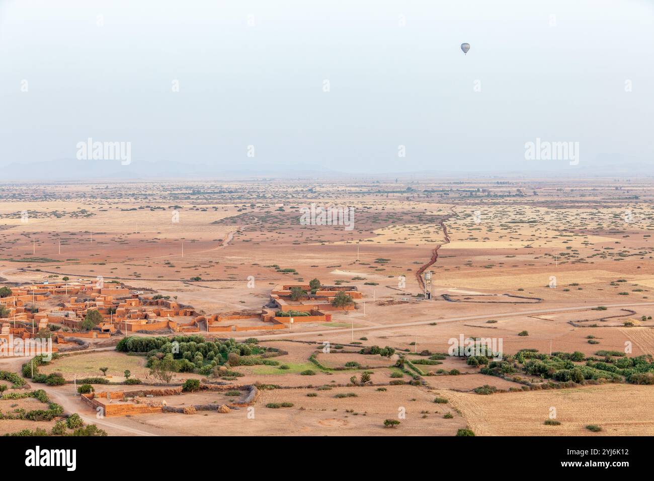 Mongolfiera che sorvola una pianura desertica ai piedi delle montagne marocchine dell'Atlante Foto Stock