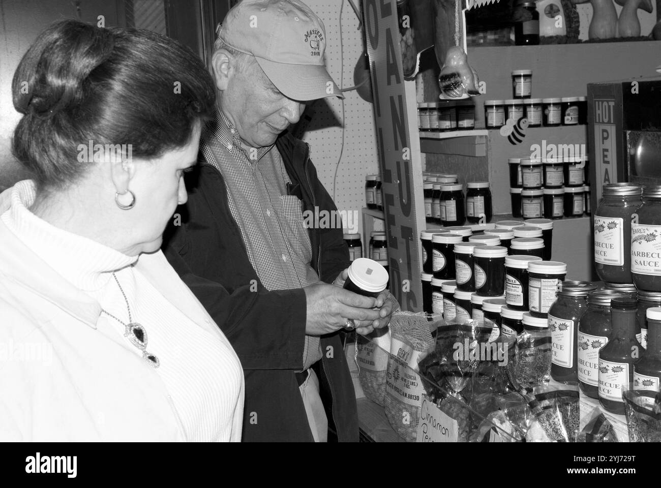 Coppia caucasica senior, dai 60 ai 65 anni, che sfoglia vasi di gelatina e marmellata al WNC Farmers Market di Asheville, North Carolina, Stati Uniti. Foto Stock