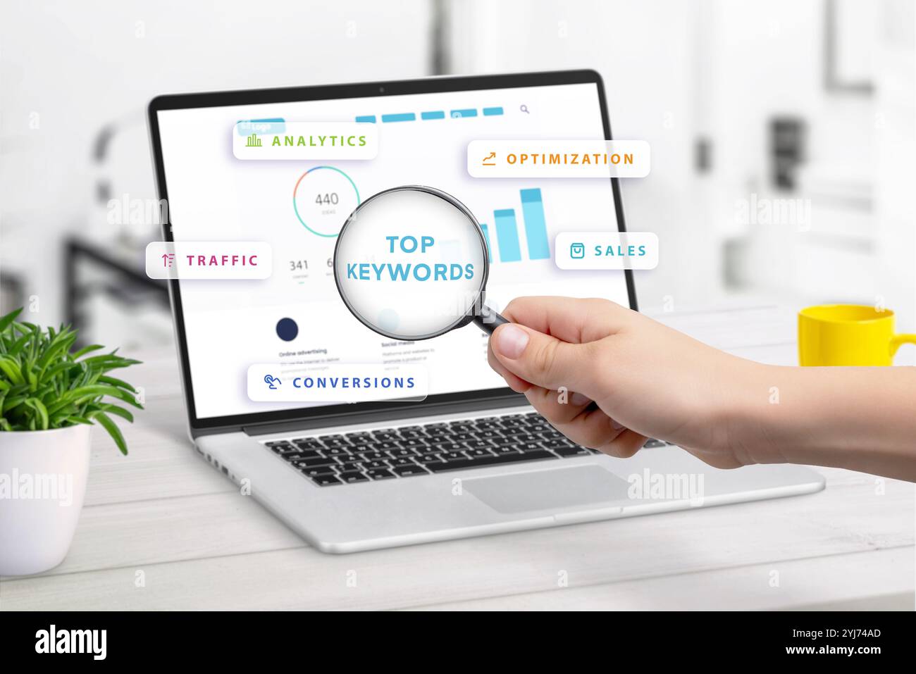 Cerca le parole chiave principali visualizzate sullo schermo del notebook con statistiche sulle parole chiave, circondate da icone per analisi, traffico, conversioni, ottimizzazione e. Foto Stock
