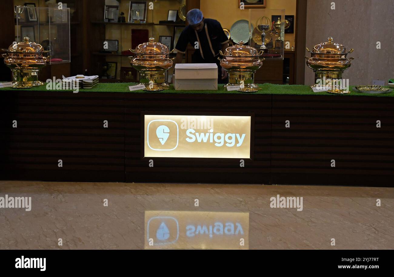 Mumbai, India. 13 novembre 2024. Il logo Swiggy è visibile sotto un bancone all'interno della Borsa Nazionale (NSE) durante la cerimonia di quotazione. Credito: SOPA Images Limited/Alamy Live News Foto Stock