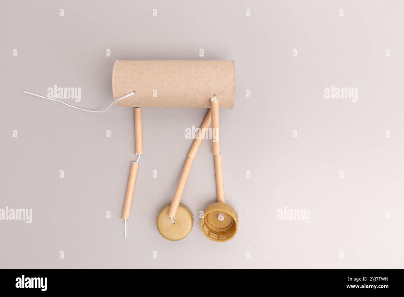 Gruppo gambe di burattini fai da te con renne utilizzando cordoncino di cartone e tappi per bottiglie. Primo piano su sfondo neutro, perfetto per l'artigianato natalizio e il riciclaggio Foto Stock