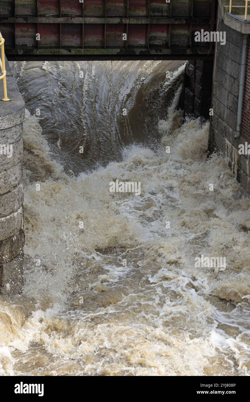 Il potente flusso d'acqua che scorre attraverso le dighe dopo forti piogge, creando intense correnti e onde schiumose Foto Stock