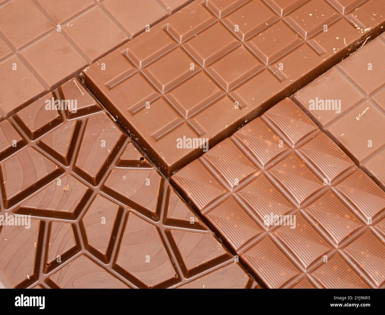 Schema di sfondo della barretta di cioccolato di diversi tipi. Consistenza astratta fatta di prodotti alimentari dolci. Full frame rivestito con le famose caramelle. Foto Stock