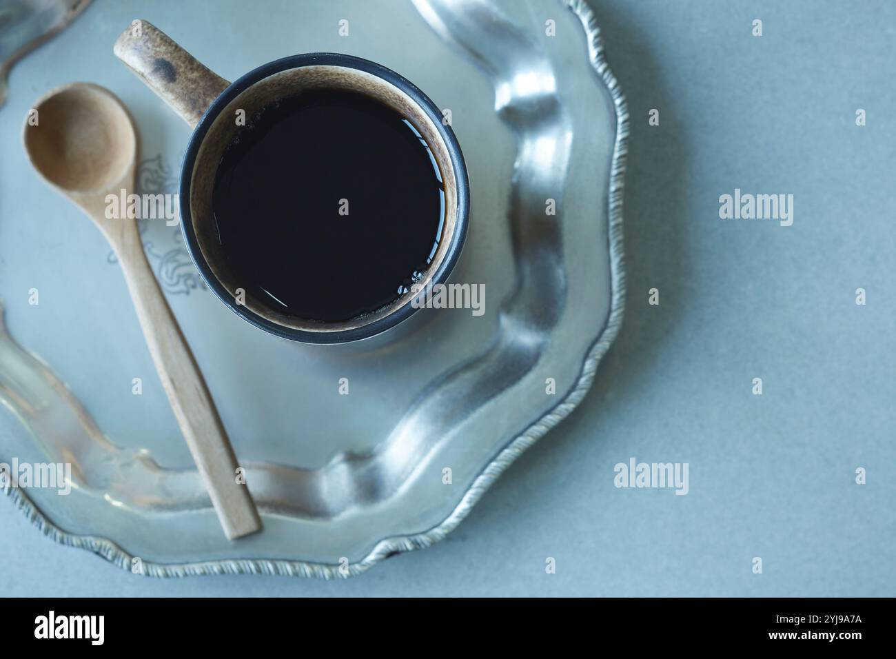 Tazza da caffè e cucchiaio di legno sul vassoio argento Foto Stock