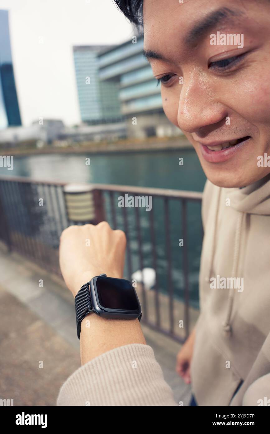 Uomo che controlla il suo smartwatch Foto Stock