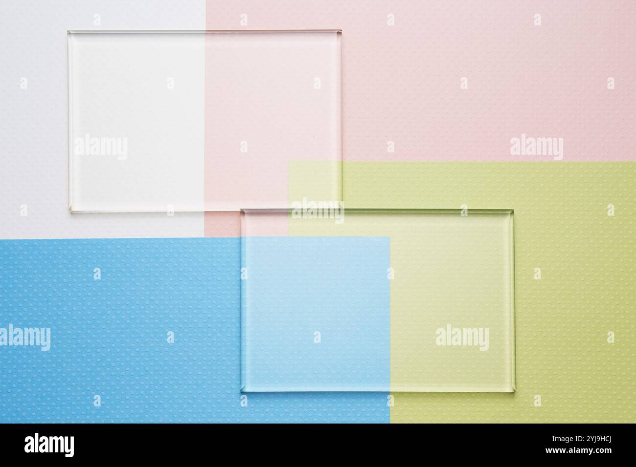 Due bicchieri forati allineati su una pila di quattro carta colorata Foto Stock