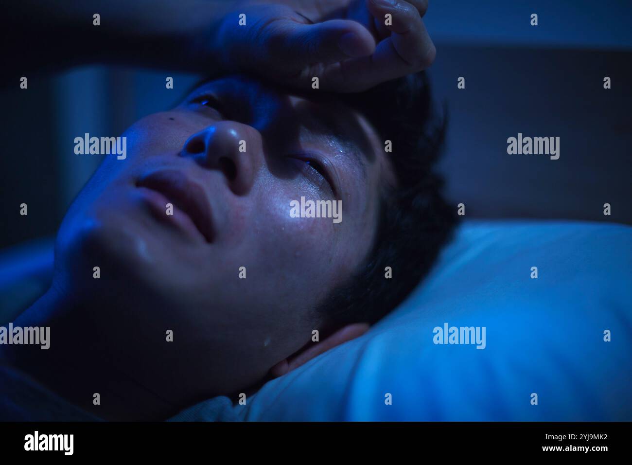 Uomo incapace di dormire a causa della notte tropicale Foto Stock