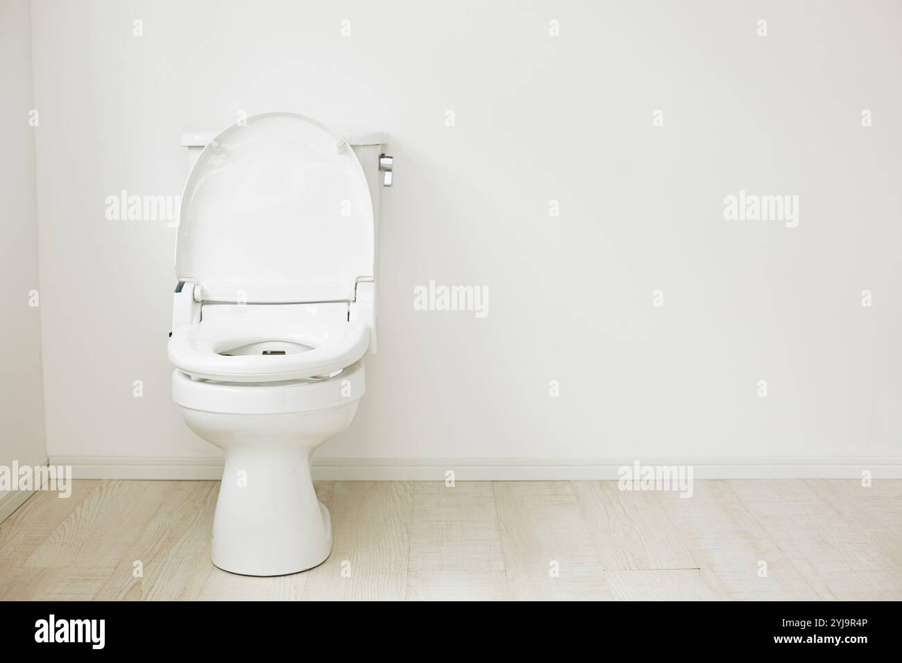 WC con coperchio aperto nello spazio tra pavimento bianco e parete Foto Stock