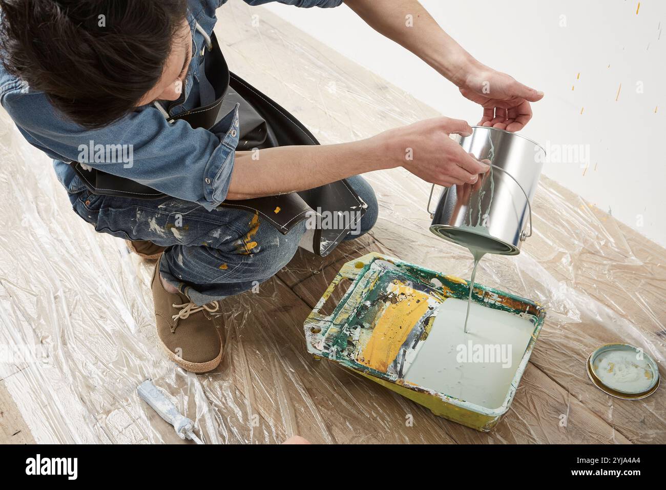 Uomo che versa vernice in una mazza Foto Stock