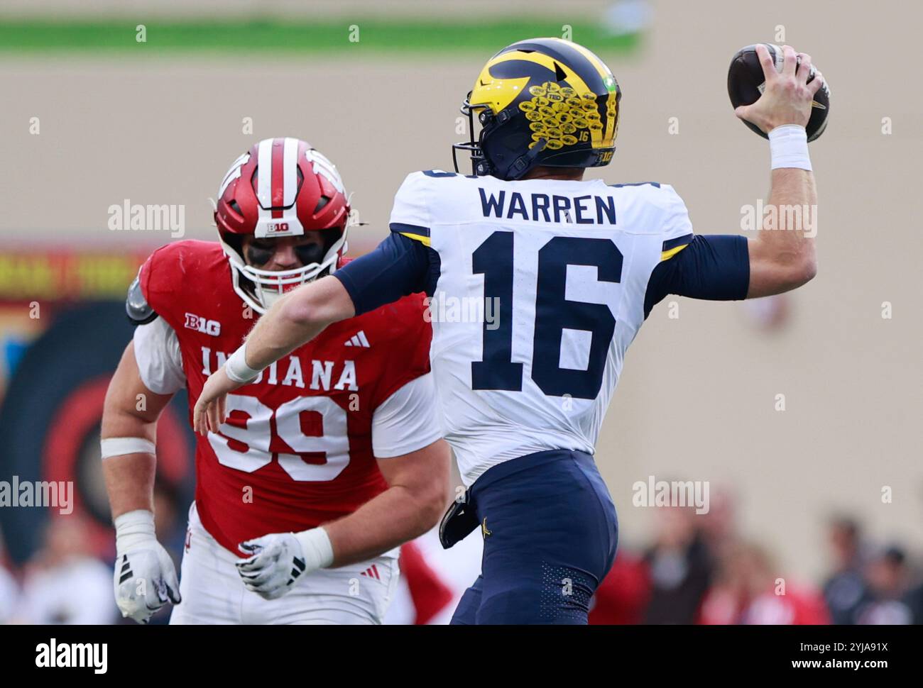 Bloomington, Stati Uniti. 9 novembre 2024. Il quarterback dei Michigan Wolverines Davis Warren (16) lanciò contro l'uomo della linea difensiva degli Indiana Hoosiers James Carpenter (99) durante una partita di football NCAA a Bloomington, Ind L'Indiana ha battuto il Michigan 20-15. Credito: SOPA Images Limited/Alamy Live News Foto Stock