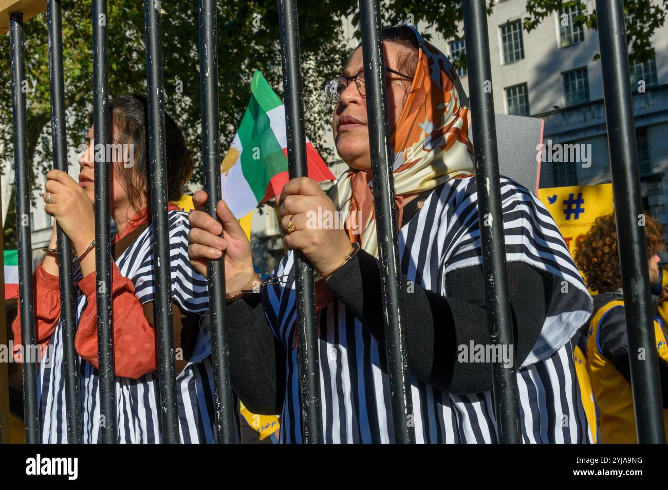 Londra, Regno Unito. 20 ottobre 2018. Le donne in abito da prione si trovano dietro le sbarre della prigione alla protesta. Dietro lo striscione "democrazia in Iran con Maryam Rajavi”, i Mujaheddin del popolo iraniano hanno protestato contro l'attuale regime repressivo in Iran, con una scommessa e tre donne detenute in una cella carceraria che illustra il regno del terrore e chiede la fine delle esecuzioni in quel paese, i manifesti ci hanno ricordato che il regime iraniano è detentore del record mondiale delle esecuzioni. Rajavi, il leader del PMOI, ha elaborato un manifesto in 10 punti che chiede un sistema giuridico moderno, la parità di genere e la politica e così via Foto Stock