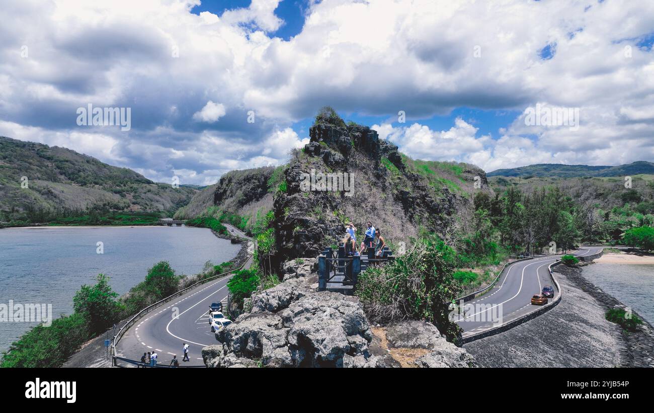 Un gruppo di individui che si erge sulla cima di una montagna a Mauritius, godendo della splendida vista aerea della natura. Foto Stock