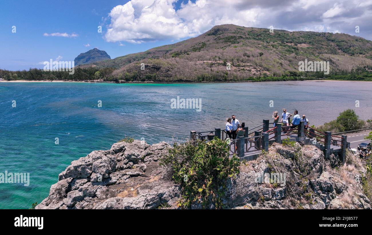 Un gruppo di individui si erge sulla cima di una scogliera a Mauritius, ammirando la vista aerea mozzafiato del paesaggio naturale. Foto Stock