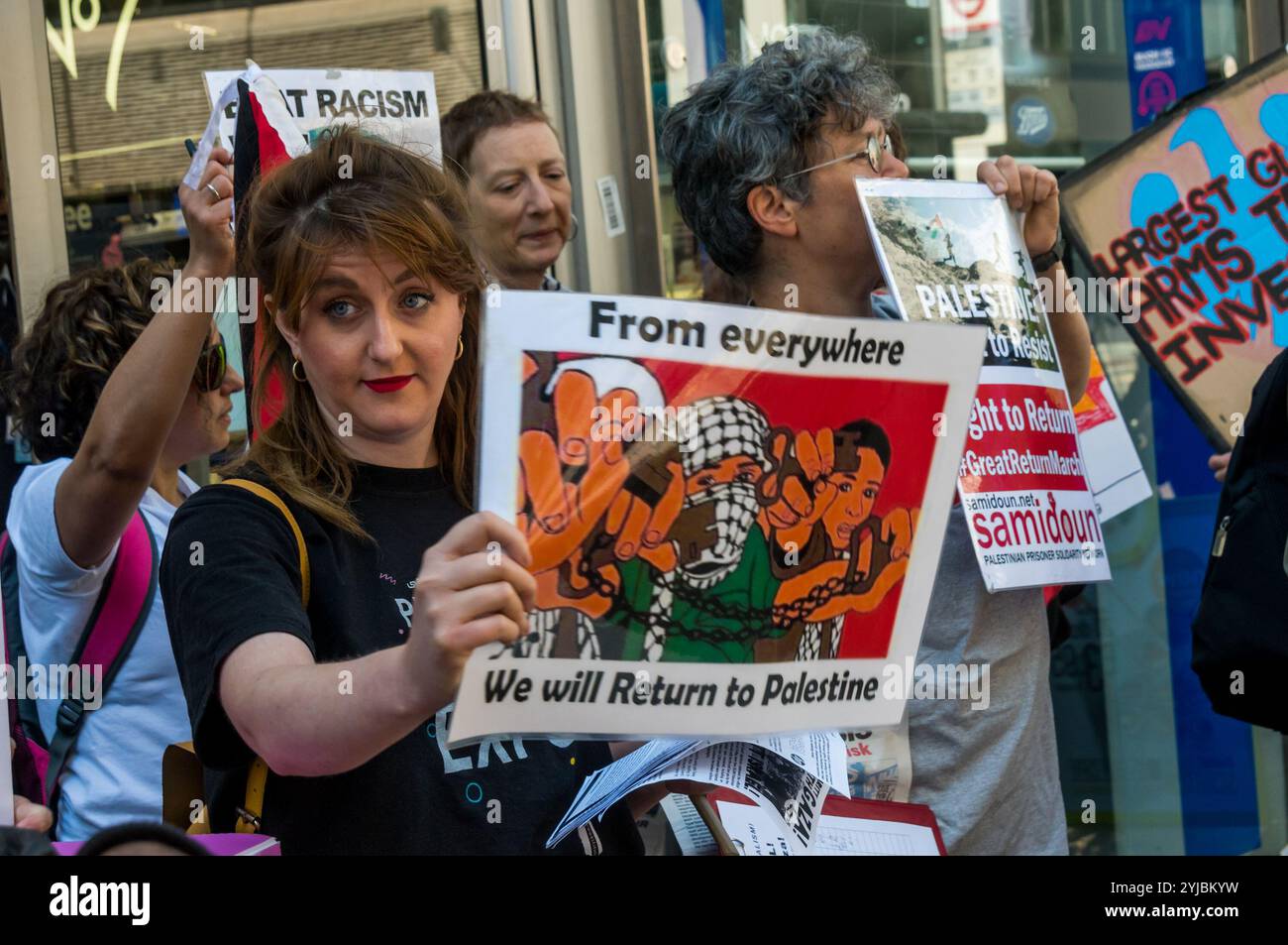 Londra, Regno Unito. 19 maggio 2018. Una donna tiene in mano un poster che mostra i palestinesi che tengono in mano le chiavi delle proprietà da cui sono stati costretti a uscire nel 1948 . I manifestanti del gruppo comunista rivoluzionario e della vittoria all'Intifada chiedono la fine di tutto il sostegno britannico a Israele dopo il barbaro massacro da parte di cecchini israeliani di manifestanti disarmati che hanno partecipato alla grande marcia di ritorno a Gaza, uccidendo oltre 60 persone e ferendone gravemente migliaia. Si ritiene che molte delle armi usate per uccidere i manifestanti siano state fornite da compagnie di armamento britanniche. La protesta è iniziata fuori da una filiale della Barclays Bank che ha ripreso Foto Stock