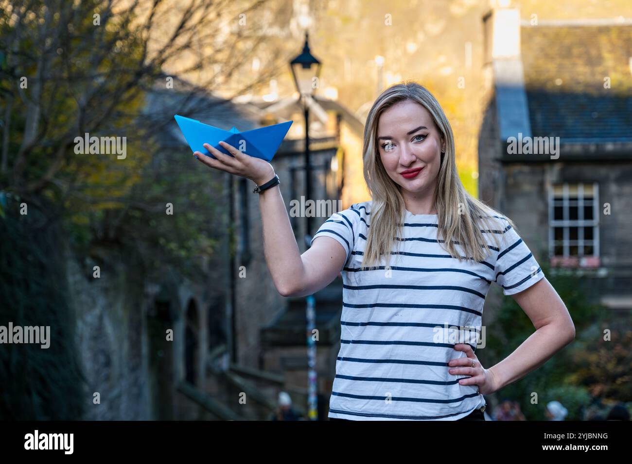 Edimburgo, Scozia, Regno Unito, 14 novembre 2024, Push the Boat Out: La premiata cantante folk Iona Fyfe posa con un origami paper boat nel Vennel, l'iconica location di Edimburgo per promuovere il festival nazionale di poesia scozzese che si svolge dal 22 al 24 novembre. Con 50 eventi che mostrano alcune delle stelle più brillanti della poesia, della musica e della parola parlata, Iona sarà il titolo di una serata di canzoni fuse con la poesia presso i Dovecot Studios sabato 23 novembre. Crediti: Sally Anderson/Alamy Live News Foto Stock